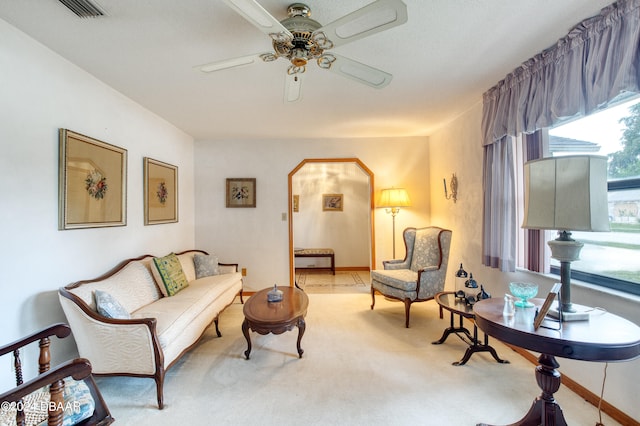 living area with light carpet and ceiling fan