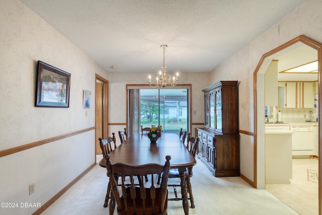 dining room with a textured ceiling and an inviting chandelier