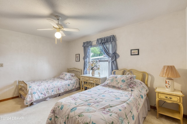 bedroom featuring ceiling fan, a textured ceiling, and light colored carpet