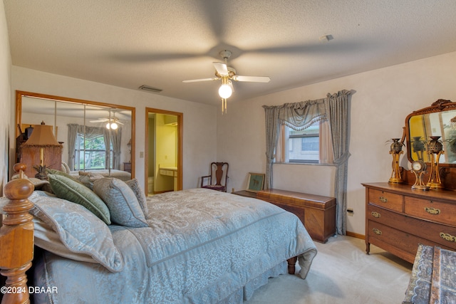 carpeted bedroom with a textured ceiling, ceiling fan, and connected bathroom