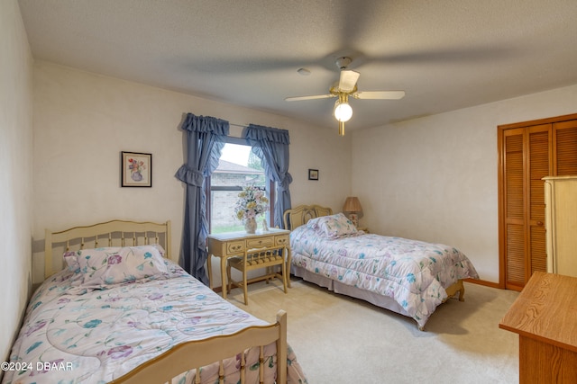 bedroom with a closet, a textured ceiling, carpet flooring, and ceiling fan