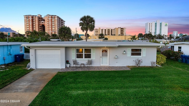 single story home featuring a garage and a yard