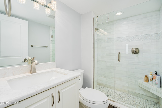 bathroom featuring vanity, toilet, and an enclosed shower