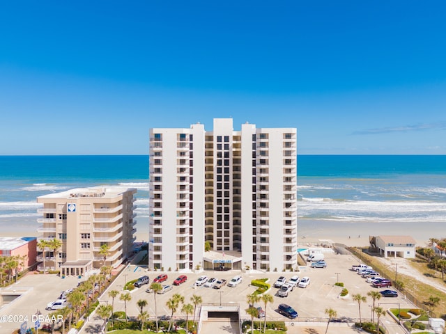 view of property with a water view and a beach view