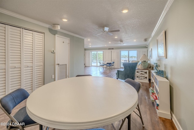 dining area featuring hardwood / wood-style flooring, ceiling fan, crown molding, and a textured ceiling