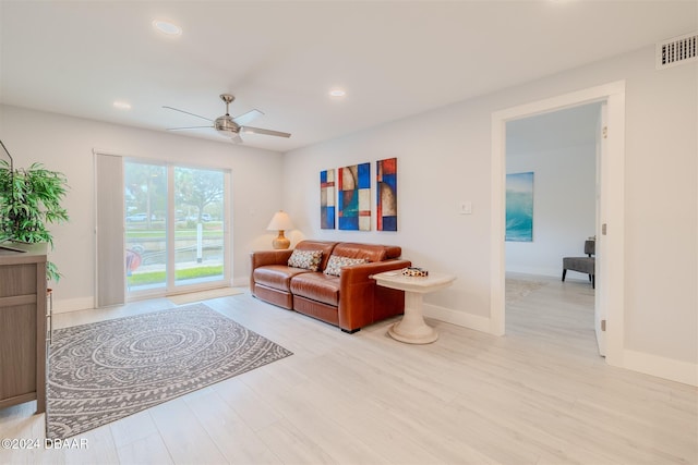 living room with light hardwood / wood-style floors and ceiling fan