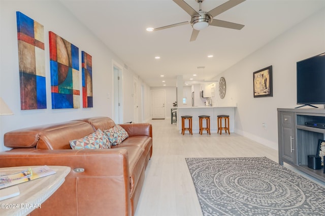 living room with ceiling fan and light wood-type flooring