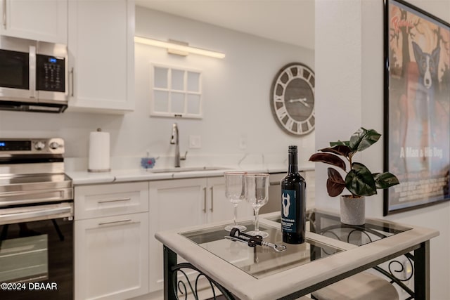 kitchen with white cabinetry, sink, and appliances with stainless steel finishes