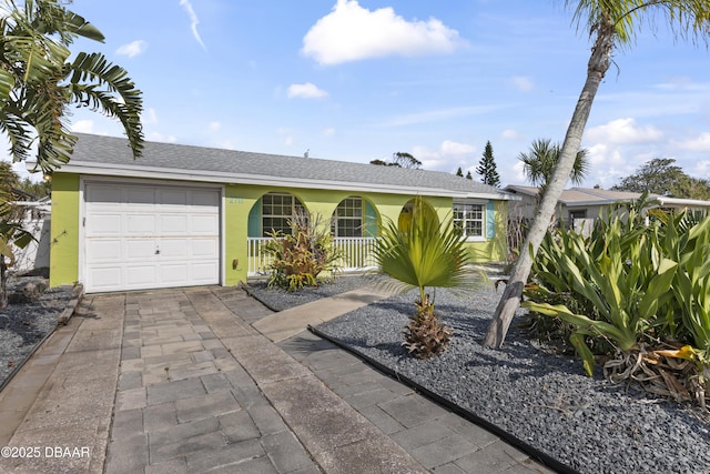 2711 Dach Ave, Daytona Beach, FL 32118 - ranch-style home featuring a shingled roof, an attached garage, a porch, concrete driveway, and stucco siding