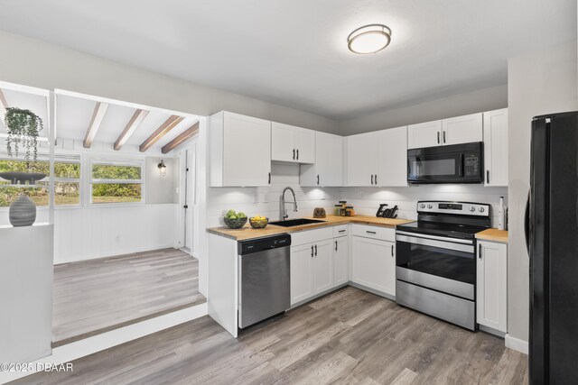 2711 Dach Ave, Daytona Beach, FL 32118 - kitchen with black appliances, a sink, butcher block countertops, and light wood-style floors