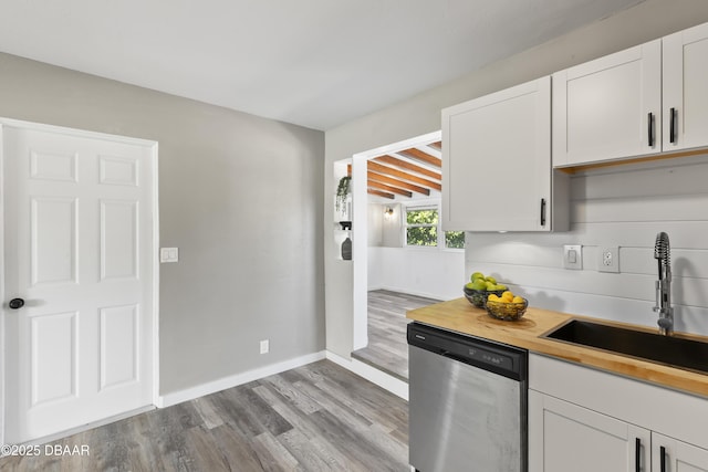 2711 Dach Ave, Daytona Beach, FL 32118 - kitchen featuring wooden counters, white cabinets, dishwasher, a sink, and wood finished floors