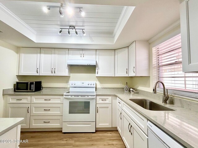 kitchen with white appliances, a raised ceiling, white cabinetry, and sink