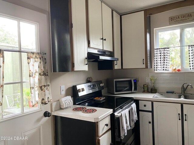 kitchen with white cabinetry, sink, backsplash, and stainless steel appliances