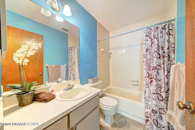 full bathroom featuring tile patterned flooring, vanity, toilet, and shower / bath combination with curtain