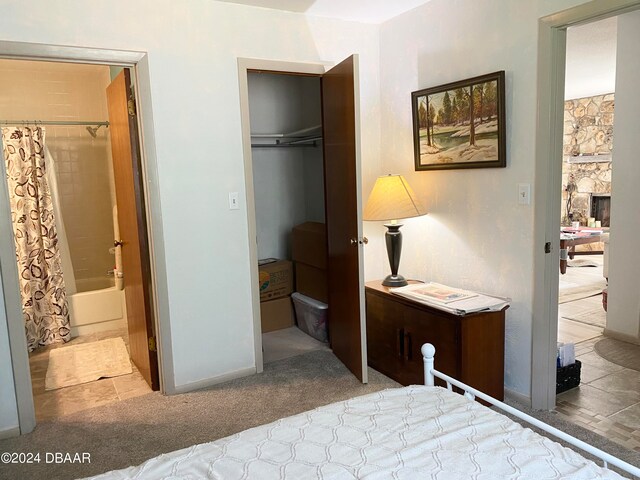 bedroom featuring ensuite bath, light carpet, a closet, and a spacious closet