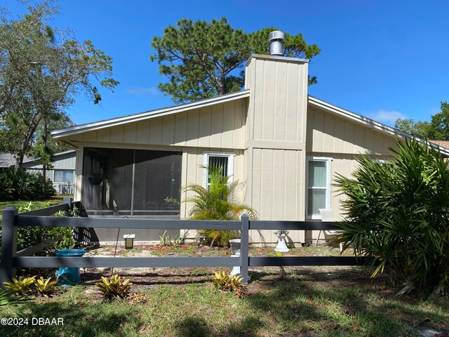 rear view of property featuring a sunroom