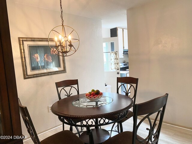 dining room with light wood-type flooring and a notable chandelier