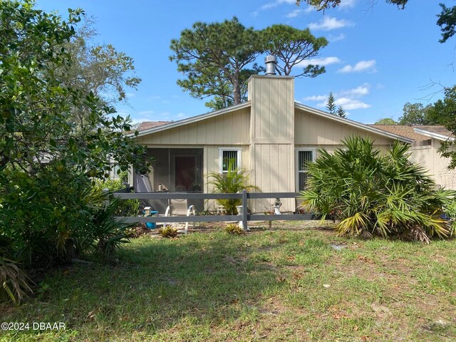 view of home's exterior featuring a sunroom and a yard