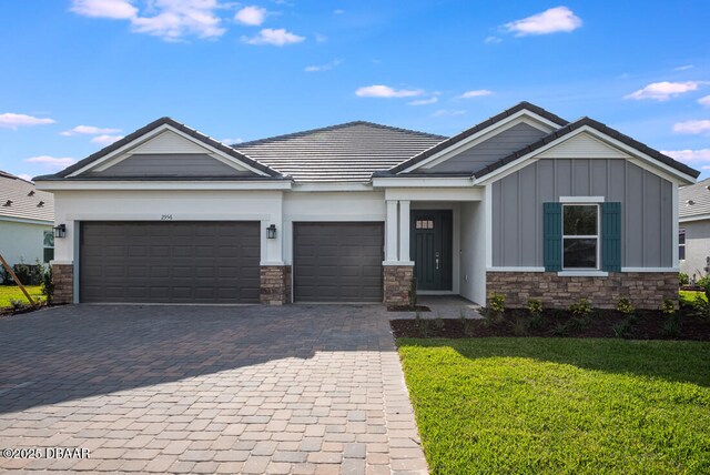 craftsman-style home featuring a garage and a front lawn