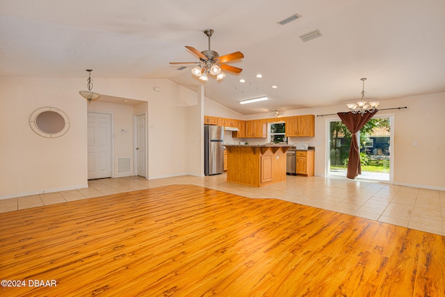 unfurnished living room with ceiling fan with notable chandelier, lofted ceiling, and light tile patterned floors