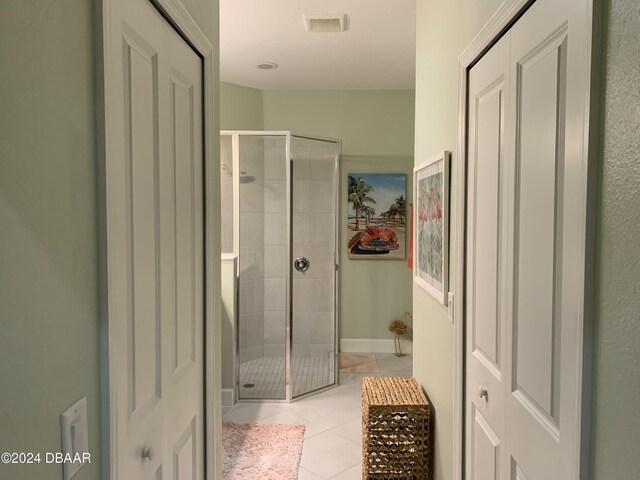 bathroom with tile patterned floors and a shower with shower door