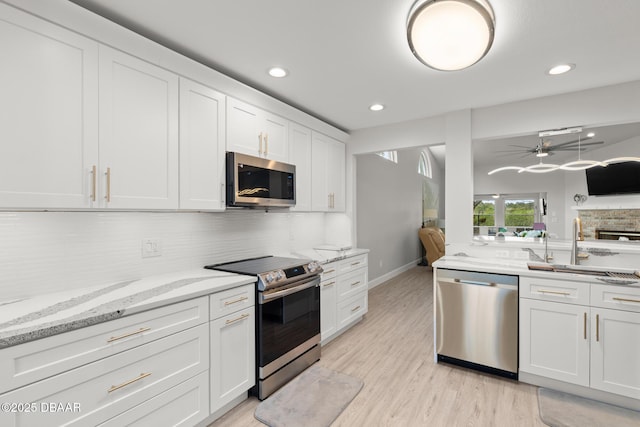 kitchen featuring backsplash, white cabinetry, sink, and stainless steel appliances