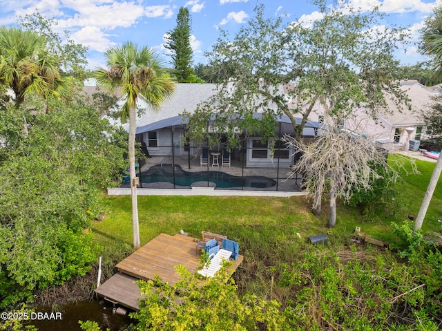 back of property featuring a lawn, glass enclosure, and a patio area