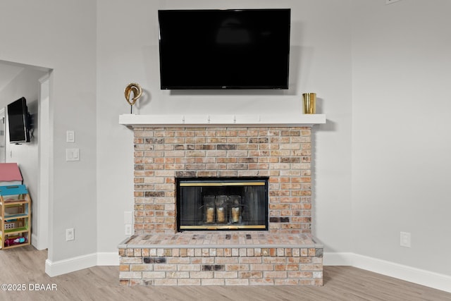 details featuring hardwood / wood-style floors and a brick fireplace