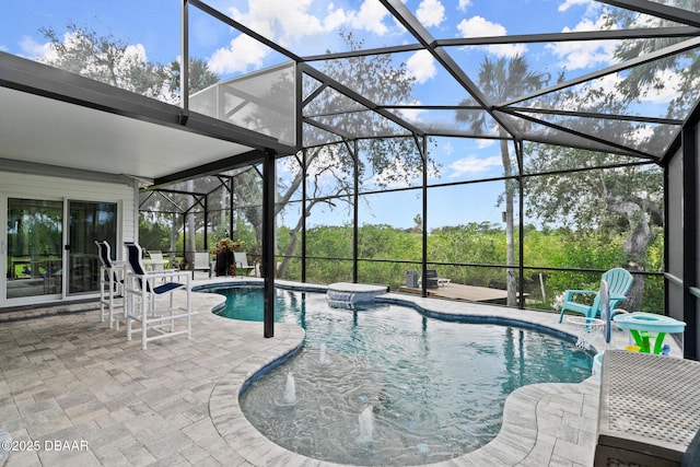 view of pool with pool water feature, glass enclosure, and a patio