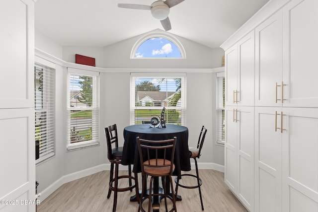 dining room with light wood-type flooring, vaulted ceiling, and ceiling fan