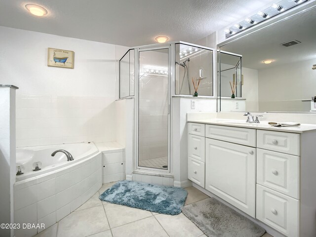 bathroom featuring shower with separate bathtub, a textured ceiling, tile patterned floors, and vanity