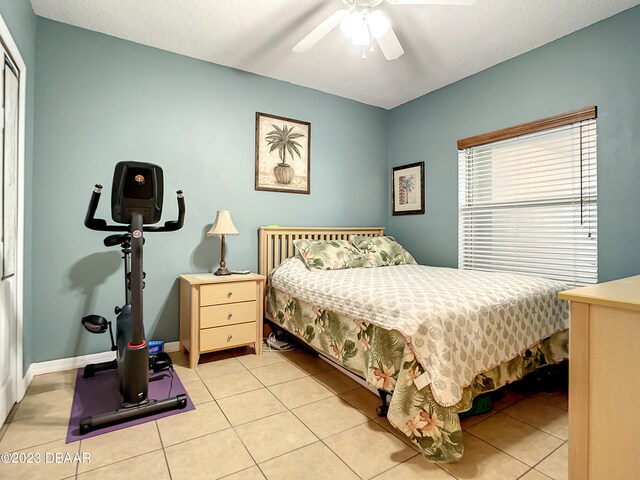 tiled bedroom with a textured ceiling and ceiling fan