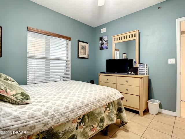 tiled bedroom featuring ceiling fan