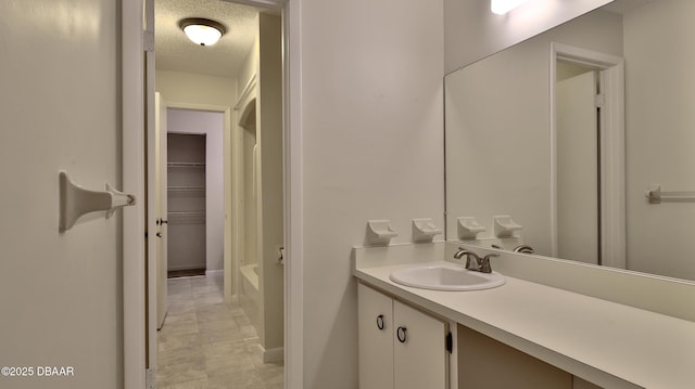 201 Pine Cone Trl, Ormond Beach, FL 32174 - full bathroom featuring a tub to relax in, vanity, and a textured ceiling