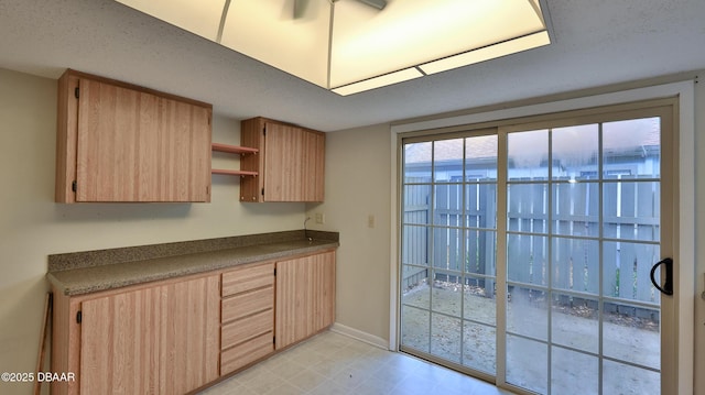 201 Pine Cone Trl, Ormond Beach, FL 32174 - kitchen with baseboards, dark countertops, open shelves, and light brown cabinets