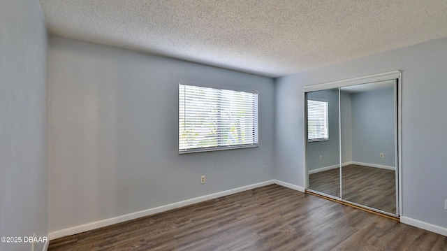 201 Pine Cone Trl, Ormond Beach, FL 32174 - unfurnished bedroom featuring baseboards, a closet, wood finished floors, and a textured ceiling