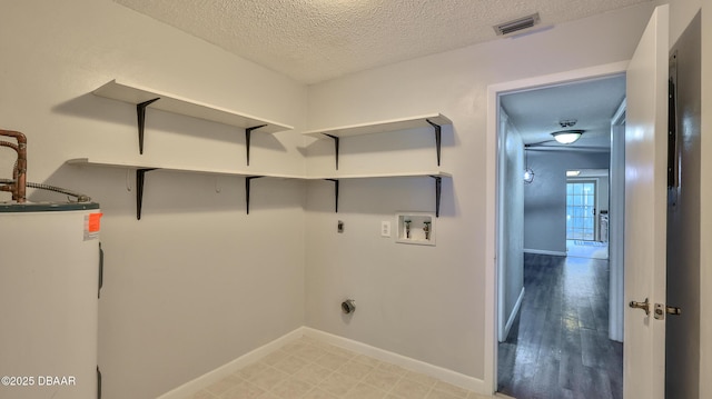 201 Pine Cone Trl, Ormond Beach, FL 32174 - laundry room featuring electric water heater, a textured ceiling, visible vents, laundry area, and washer hookup