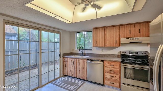 201 Pine Cone Trl, Ormond Beach, FL 32174 - kitchen with under cabinet range hood, a sink, dark countertops, ceiling fan, and appliances with stainless steel finishes