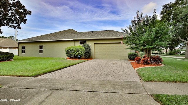4269 Mayfair Ln, Port Orange, FL 32129 - view of front of home featuring stucco siding, an attached garage, decorative driveway, a front yard, and a shingled roof