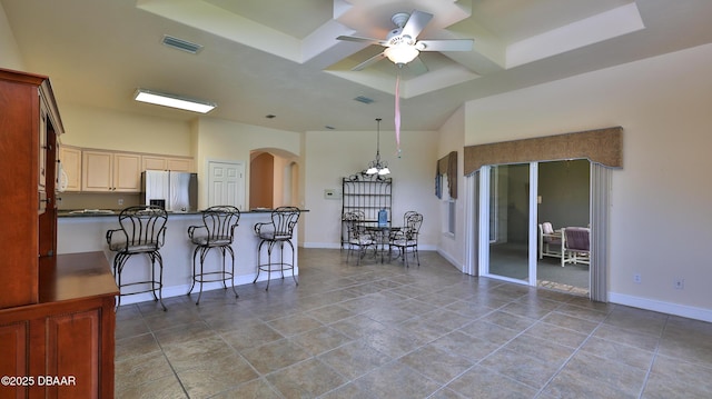 4269 Mayfair Ln, Port Orange, FL 32129 - kitchen with stainless steel refrigerator with ice dispenser, arched walkways, dark countertops, ceiling fan, and a kitchen bar
