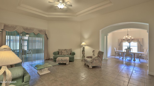 4269 Mayfair Ln, Port Orange, FL 32129 - living area featuring arched walkways, a chandelier, a raised ceiling, a ceiling fan, and a towering ceiling