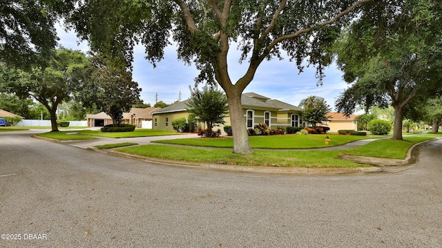 4269 Mayfair Ln, Port Orange, FL 32129 - view of front of house with curved driveway, a front yard, and a garage