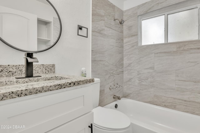 full bathroom with vanity, tiled shower / bath, and toilet