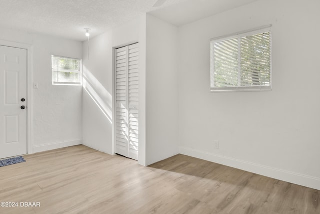 entrance foyer with light hardwood / wood-style floors and a textured ceiling