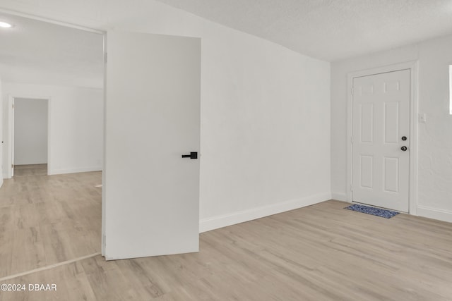 spare room with light hardwood / wood-style flooring and a textured ceiling