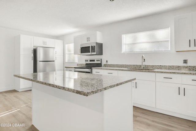 kitchen with a center island, sink, a healthy amount of sunlight, and stainless steel appliances