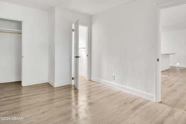 unfurnished bedroom with light hardwood / wood-style flooring and a closet