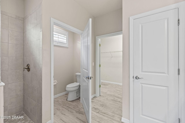 3402 Torre Blvd, New Smyrna Beach, FL 32168 - full bathroom featuring a shower stall, toilet, wood finished floors, a spacious closet, and baseboards