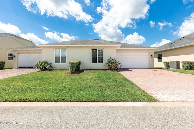 3402 Torre Blvd, New Smyrna Beach, FL 32168 - ranch-style house featuring stucco siding, a garage, decorative driveway, a front lawn, and central AC unit
