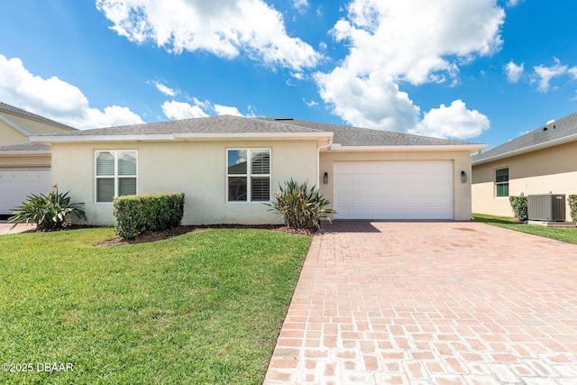 3402 Torre Blvd, New Smyrna Beach, FL 32168 - ranch-style house with decorative driveway, stucco siding, an attached garage, a front yard, and central air condition unit